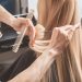 Hairdresser is cutting long blond hair in hair salon