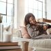 Woman relax on couch with puppy, happy and content at home with pet, happiness together with peace in living room. .Female cuddle dog, love for animals with smile and care, stress relief and comfort.